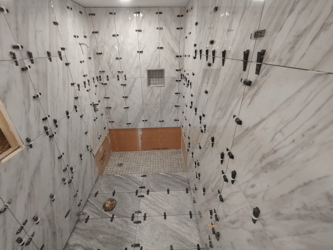 An image showing an interior space with a marble-like flooring pattern featuring dark veins, walls covered with a similar design, and numerous round objects of various sizes scattered throughout the room.