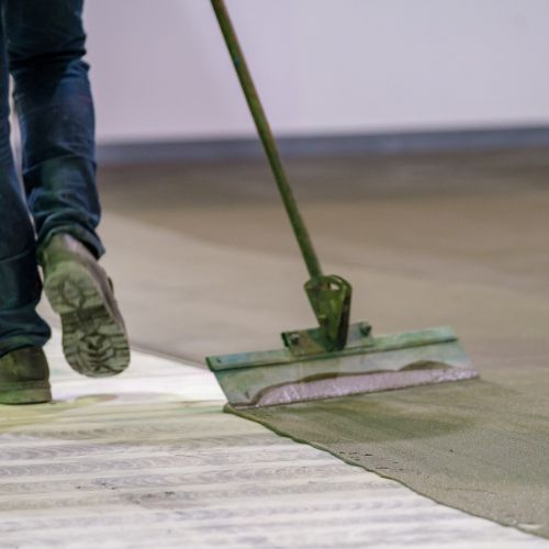 The image shows two different views of a person sweeping a floor with a dustpan.