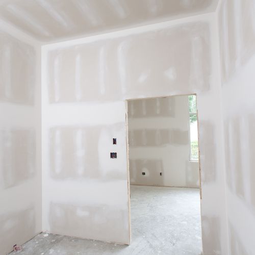 The image shows an interior space with walls partially covered in drywall panels, indicating a construction or renovation process in progress.